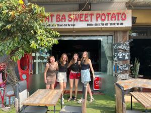 a group of three women standing in front of a restaurant at Cat Ba Sweet Potato Homestay in Cat Ba