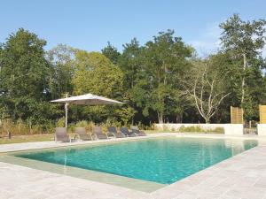 - une piscine avec des chaises et un parasol dans l'établissement Le Domaine des Cyclamens, à Verneuil-sur-Indre