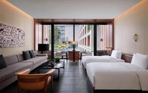 a hotel room with two beds and a couch at Lohkah Hotel & Spa-Free Welcome Fruit Plate in Xiamen