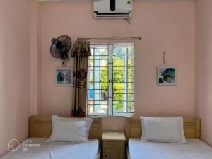 um quarto com 2 camas e uma janela em Cat Ba Sweet Potato Homestay em Ilha de Cát Bà