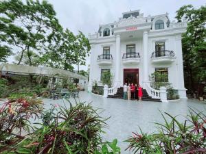 a group of people standing in front of a white building at Villa Blueware - Venuestay in Vĩnh Phúc