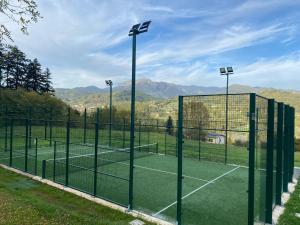 a tennis court with two tennis courts at VILLA TURRI - Luxury Country & Padel Resort in Camporgiano