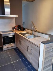 a kitchen with a sink and a stove at Maison cosy au centre de Nivelles in Nivelles