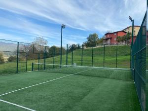 un campo da tennis con rete su un campo di VILLA TURRI - Luxury Country & Padel Resort a Camporgiano