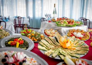 a table with many plates of food on it at Hotel City in Misano Adriatico