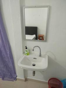 lavabo blanco en el baño con espejo en DAOH'S Rooms & Scooters, en Tanjung Rhu