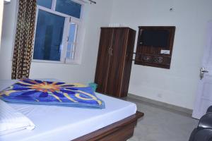 1 dormitorio con cama, ventana y TV en Himalayan Dalhousie Home Stay - Near Panchpula Water Fall en Dalhousie