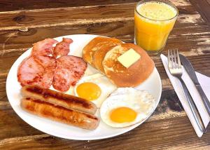 un piatto di prodotti per la colazione con uova, salsicce e pancake di Kathmandu Aagantuk Hotel a Kathmandu