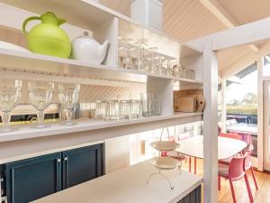 una cocina con una mesa y vasos en las estanterías en 6 person holiday home in Haarby en Brunshuse