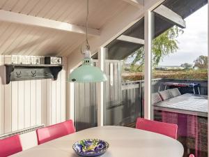 ein Esszimmer mit einem Tisch und Stühlen auf einer Terrasse in der Unterkunft 6 person holiday home in Haarby in Brunshuse