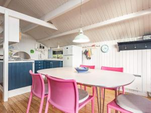 eine Küche mit einem weißen Tisch und rosa Stühlen in der Unterkunft 6 person holiday home in Haarby in Brunshuse