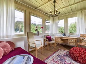 Habitación con escritorio, sillas y ventanas. en Vintage Loft en Hopfgarten im Brixental