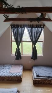 two beds in a room with two windows at KUĆA ZA ODMOR/PROSLAVE in Lukinić Senovec +35 photos