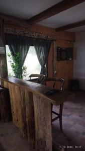 eine Holzbar in einem Zimmer mit Tisch und Stühlen in der Unterkunft KUĆA ZA ODMOR/PROSLAVE in Lukinić Senovec