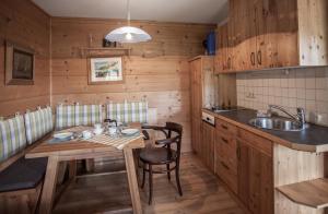 cocina con mesa de madera y fregadero en Mei Zeit Hüttendorf, en Turracher Höhe