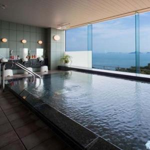 a large swimming pool in a building with water at Kyukamura Setouchi-Toyo in Saijo