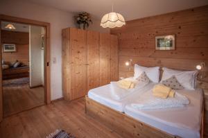 Schlafzimmer mit einem großen weißen Bett und Holzwänden in der Unterkunft Mei Zeit Hüttendorf in Turracher Hohe