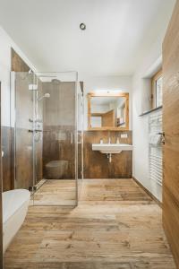 a bathroom with a shower and a tub and a sink at Dachstein West Apartment 1B in Russbach am Pass Gschütt