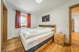 a bedroom with a large white bed and a mirror at Dachstein West Apartment 1B in Russbach am Pass Gschütt