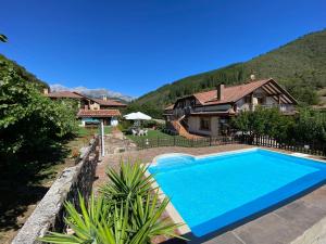 a swimming pool in front of a house at Apartamentos Rurales Valverde in Potes