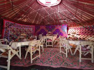 pokój ze stołami i krzesłami w namiocie w obiekcie Son-Kul Northen yurt camp w mieście Kochkorka