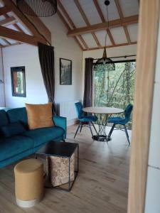 ein Wohnzimmer mit einem Sofa und einem Tisch in der Unterkunft Le Domaine des Roches' L in Gommené