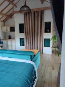 ein Wohnzimmer mit einem blauen Sofa und einigen Fenstern in der Unterkunft Le Domaine des Roches' L in Gommené