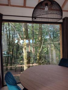 Zimmer mit einem Tisch und einem großen Fenster in der Unterkunft Le Domaine des Roches' L in Gommené