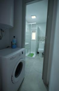 a white washing machine in a bathroom with a toilet at Apartamento in Almería