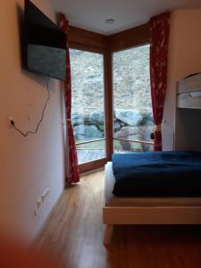 sypialnia z łóżkiem i dużym oknem w obiekcie Ferienappartment in St Oswald - Bad Kleinkirchheim Nähe der Skipiste w mieście Obertschern