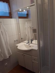 biała łazienka z umywalką i lustrem w obiekcie Ferienappartment in St Oswald - Bad Kleinkirchheim Nähe der Skipiste w mieście Obertschern