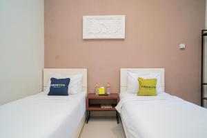 Katil atau katil-katil dalam bilik di Urbanview Hotel Bubusini Batu by RedDoorz