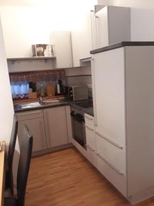 kuchnia z białymi urządzeniami i drewnianą podłogą w obiekcie Ferienappartment in St Oswald - Bad Kleinkirchheim Nähe der Skipiste w mieście Obertschern