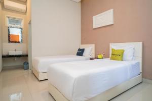 Katil atau katil-katil dalam bilik di Urbanview Hotel Bubusini Batu by RedDoorz