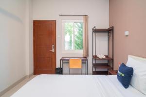 Katil atau katil-katil dalam bilik di Urbanview Hotel Bubusini Batu by RedDoorz