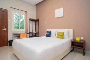 Katil atau katil-katil dalam bilik di Urbanview Hotel Bubusini Batu by RedDoorz