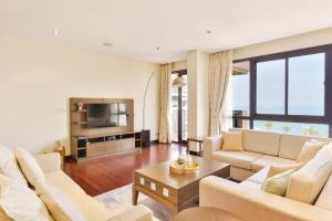 sala de estar con 2 sofás y TV en Luxury 5-star Palm Resort en Dubái