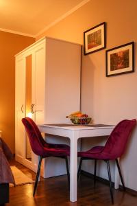 einen Tisch mit zwei Stühlen und eine Schale Obst darauf in der Unterkunft Apartment Serenade am Zwinger in Goslar