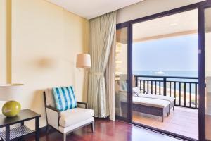 Habitación con balcón con silla y escritorio. en Luxury 5-star Palm Resort en Dubái