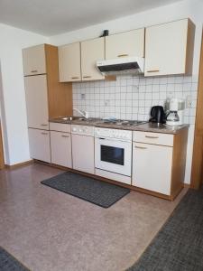 a kitchen with white cabinets and a stove top oven at Haus Illmer - Fiss in Fiss