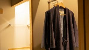 a robe hanging on a rack in a closet at Kyukamura Retreat-Azumino-Hotel in Azumino