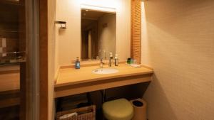 a bathroom with a sink and a mirror at Kyukamura Retreat-Azumino-Hotel in Azumino