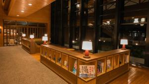 a library with a row of tables with lamps on them at Kyukamura Retreat-Azumino-Hotel in Azumino