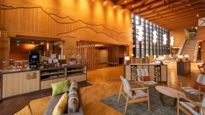 a lobby with a couch and chairs and a kitchen at Kyukamura Retreat-Azumino-Hotel in Azumino