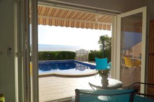 a sliding glass door to a patio with a swimming pool at ADRIATIC Luxury Villa in Okrug Gornji