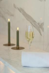 un verre de vin assis sur un comptoir avec deux bougies dans l'établissement Ombergs Golf Resort, à Ödeshög