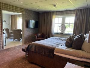 1 dormitorio con 1 cama y sala de estar en Ombergs Golf Resort en Ödeshög