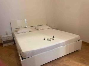 a white bed in a small room with a white mattress at Appartamento con piscina e sauna Bissone in Bissone