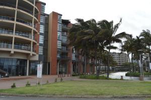 een gebouw met palmbomen ervoor bij Accommodation Front - Deluxe 6 Sleeper with Rooftop Pool in Durban