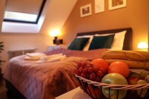 a bowl of fruit on a table next to a bed at Apartment Serenade am Zwinger in Goslar